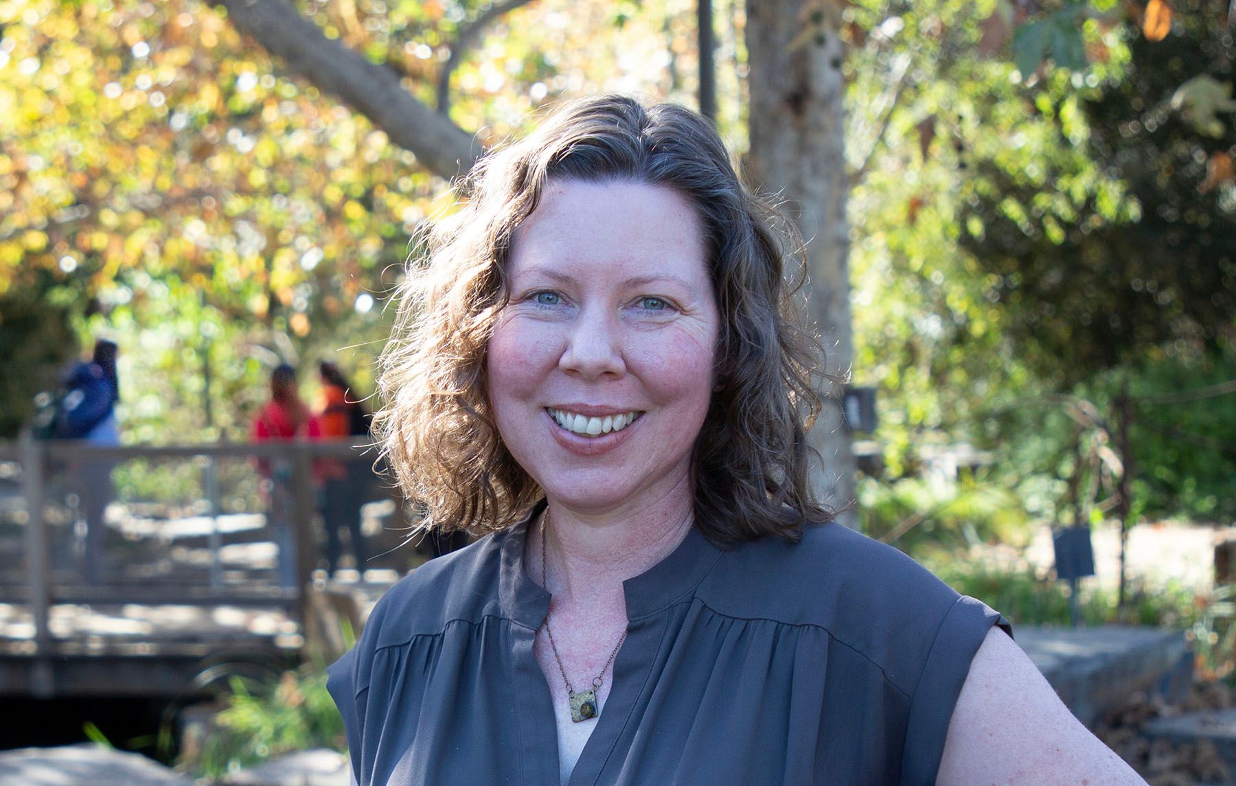 Photograph of Amy Jaecker-Jones standing in front of a pond